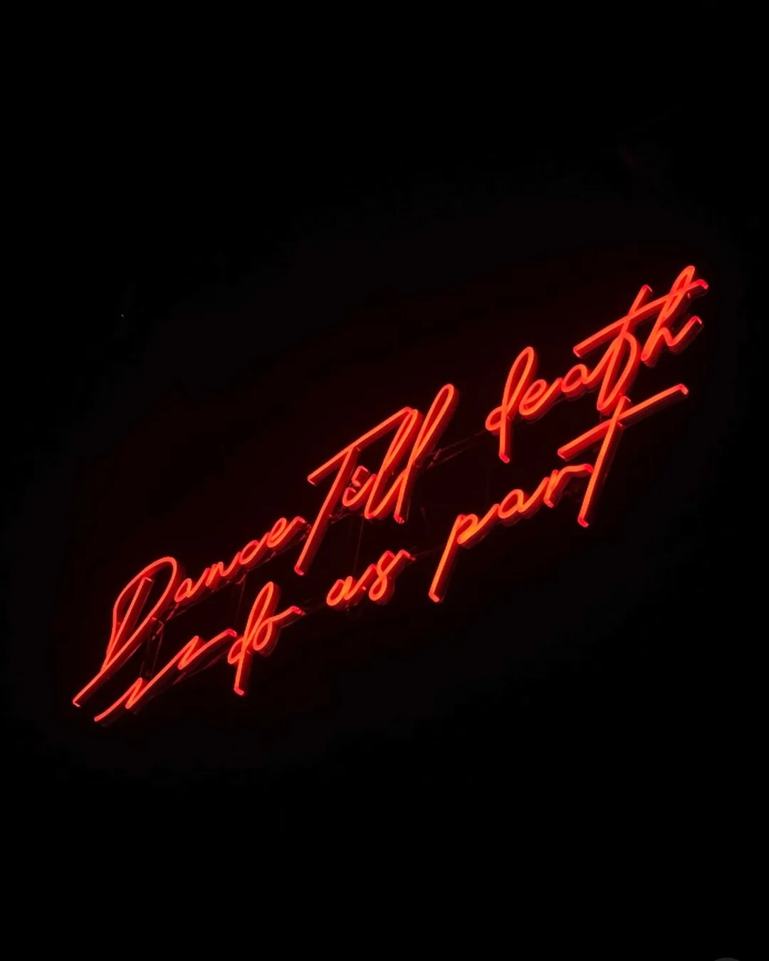 Red neon script on a dark wall at The Beatrice.