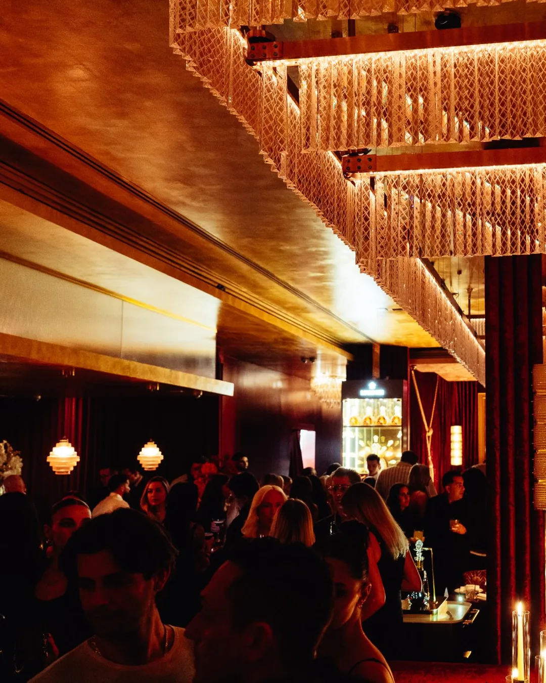 The dining room at Papi Steak, lit gold.