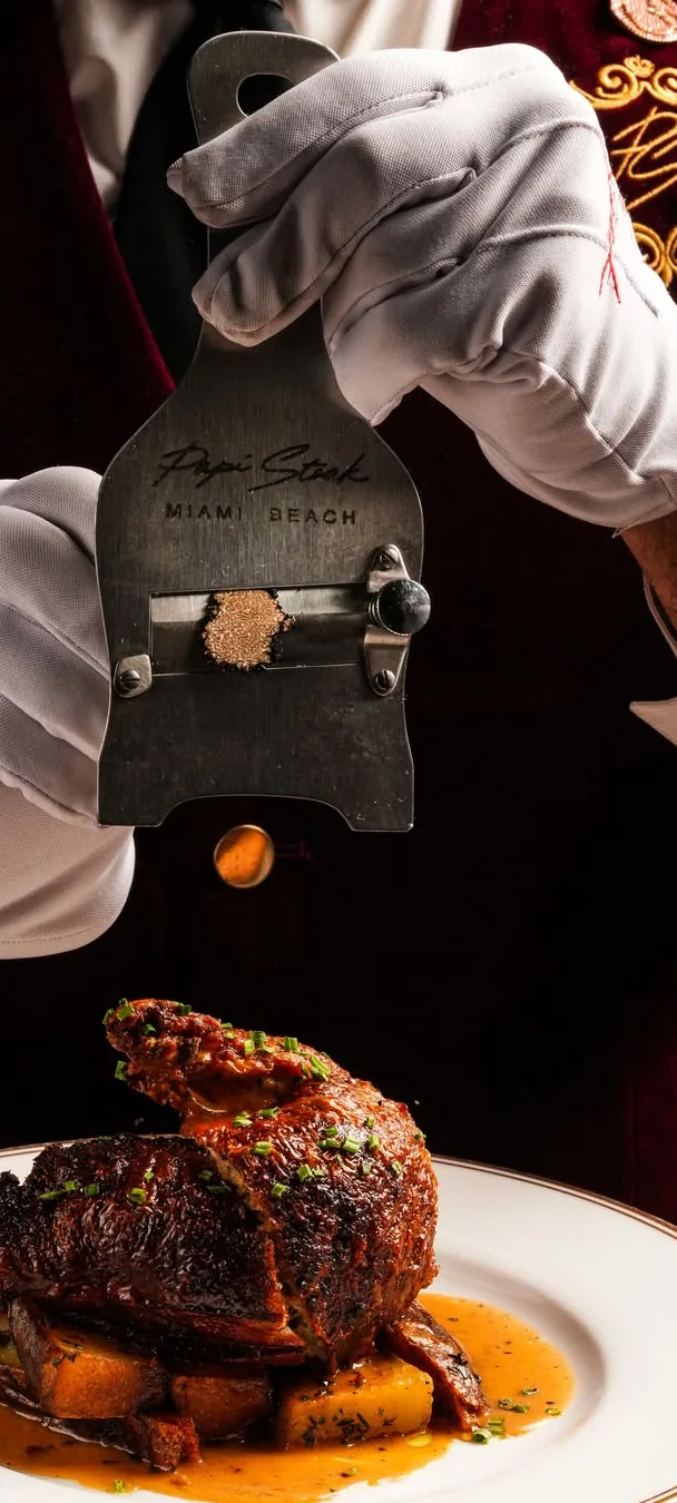 A white-gloved server shaving truffle at Papi Steak.