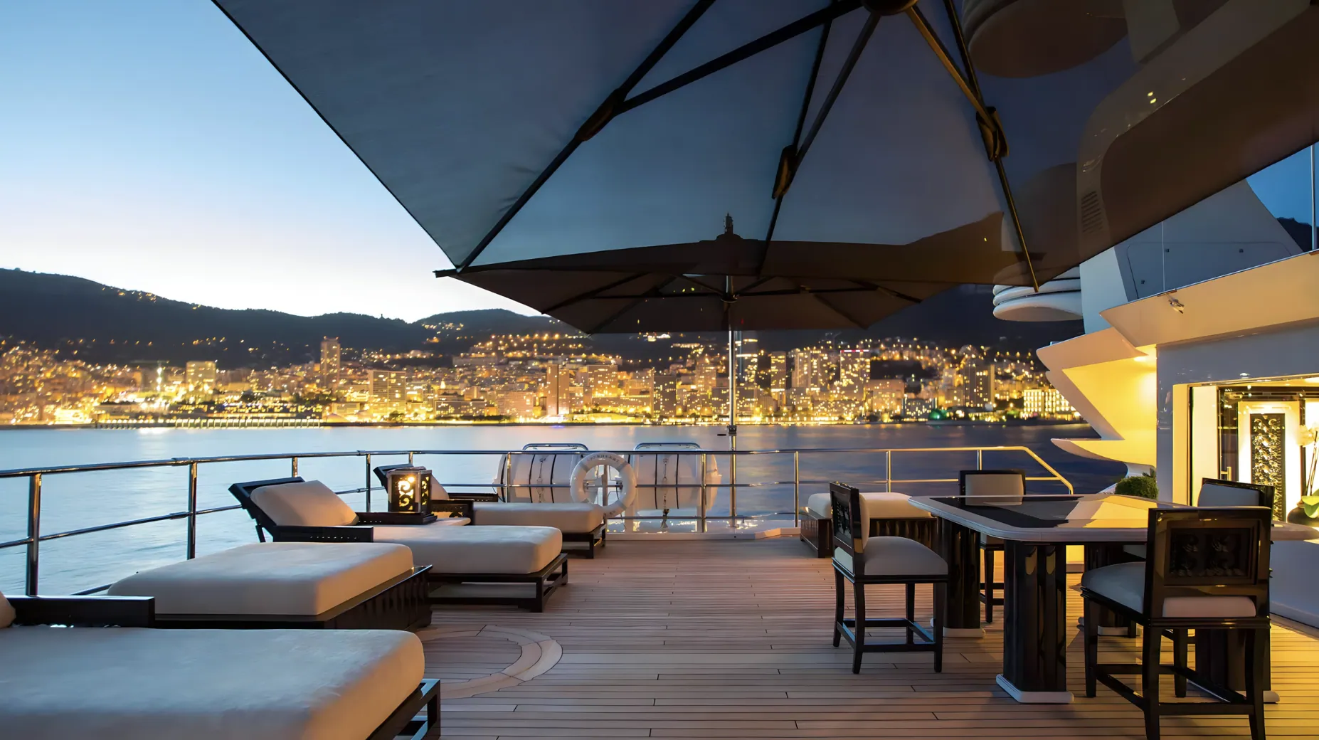 The deck of LIONESS V at blue hour, the harbour lit behind.