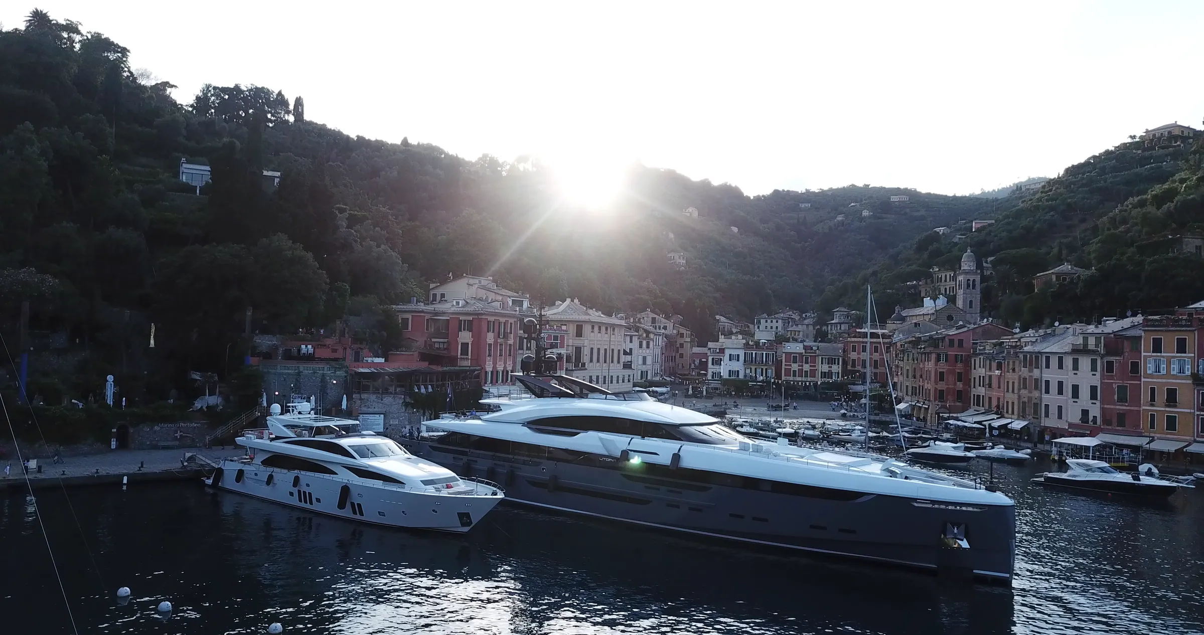 UTOPIA IV at dusk off a harbour village.